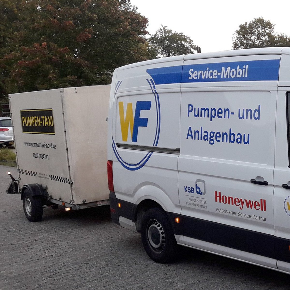 Das Fahrzeug mit der Aufschrift 'Service-Mobil' ist bereit für den Einsatz, während der Anhänger mit 'PUMPEN-TAXI' beschriftet ist.